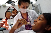 Free Dental Visit  A dental hygienist give a young girl instruction on how to brush her teeth during a free dental visit. © PhotosinMotion.net : Photos of free dental work, pictures of dentist visit, photosinmotion.net